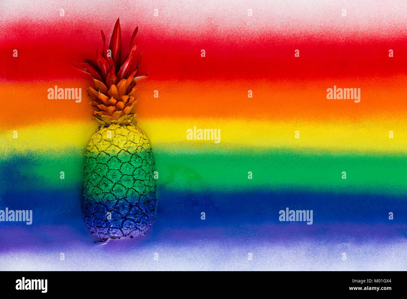 Ganze reife Ananas mit seinen Büschel Blätter in regenbogenfarbenen Streifen getarnt sprühte auf einem hölzernen Hintergrund mit Kopie Raum Stockfoto