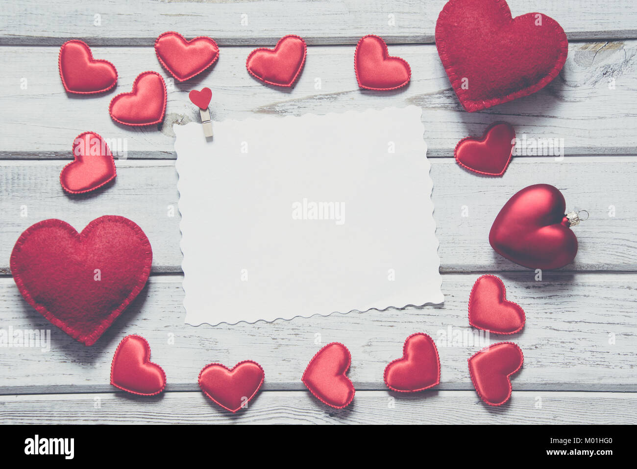 Valentine's Karte. Red textile Herzen mit Blatt für Ihren Text auf weißem Holzbrett. Vintage matt Effekt. Kopieren Sie Platz. Stockfoto