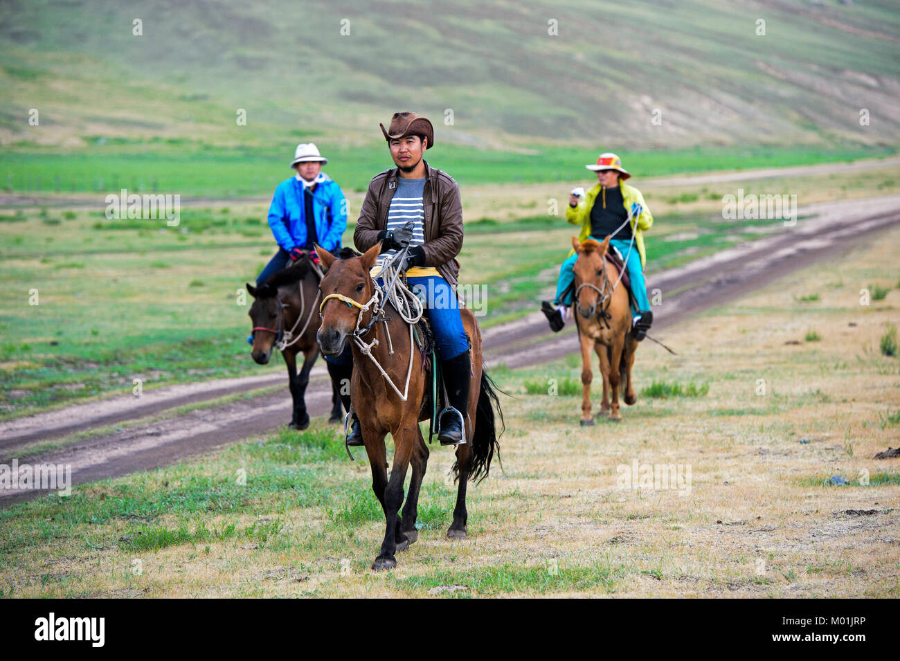 Mongolische Mann auf einem Pferd mit Touristen, die ein Pferd in der mongolischen Steppe, gorkhi-terelj Nationalpark, Mongolei Stockfoto