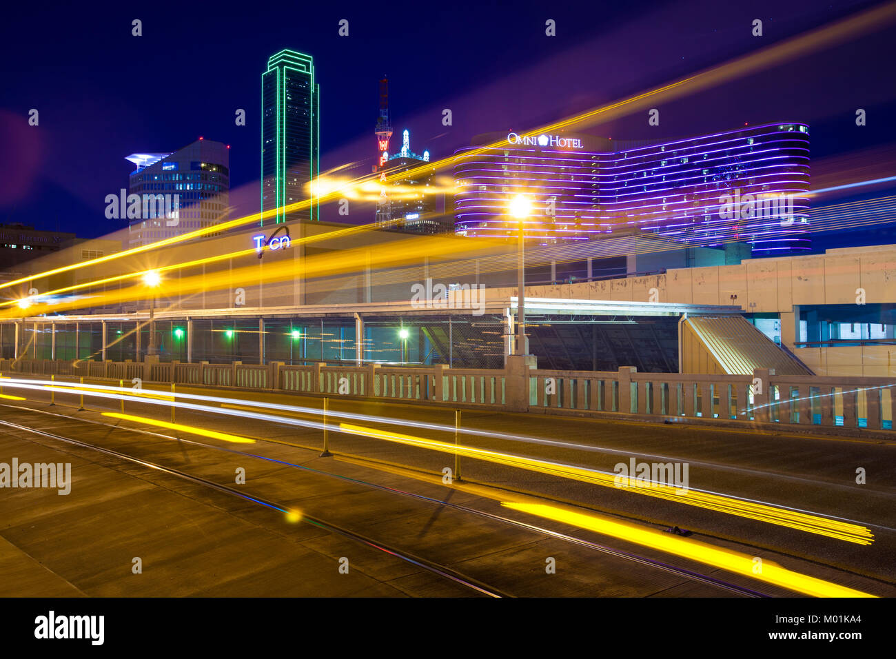 DALLAS, TX - Dezember 10, 2017, - leichte Spuren von beweglichen Straßenbahn auf dem Houston Street mit der Stadt Dallas im Hintergrund. Die Dallas Straßenbahn Stockfoto
