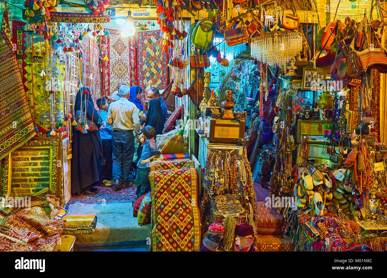 SHIRAZ, IRAN - Oktober 12, 2017: Zwei benachbarten Ständen von vakil Basar - Man bietet traditionelle Teppiche, ein anderes bietet breite Auswahl an Möbel Stockfoto