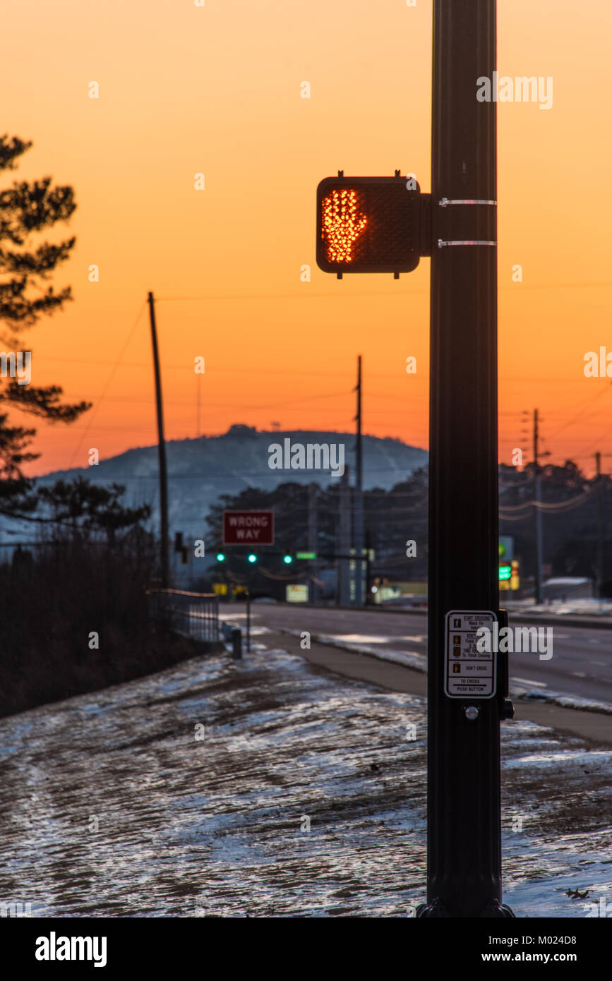 Leere Straße Szene in der Metro Atlanta, Georgia in der Nähe von Stone Mountain an einem verschneiten Tag unter einer lebhaften orange Sonnenuntergang Himmel. (USA) Stockfoto