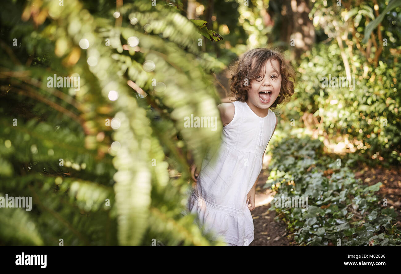 Kleine, süße Mädchen Spaß in einem tropischen Garten Stockfoto