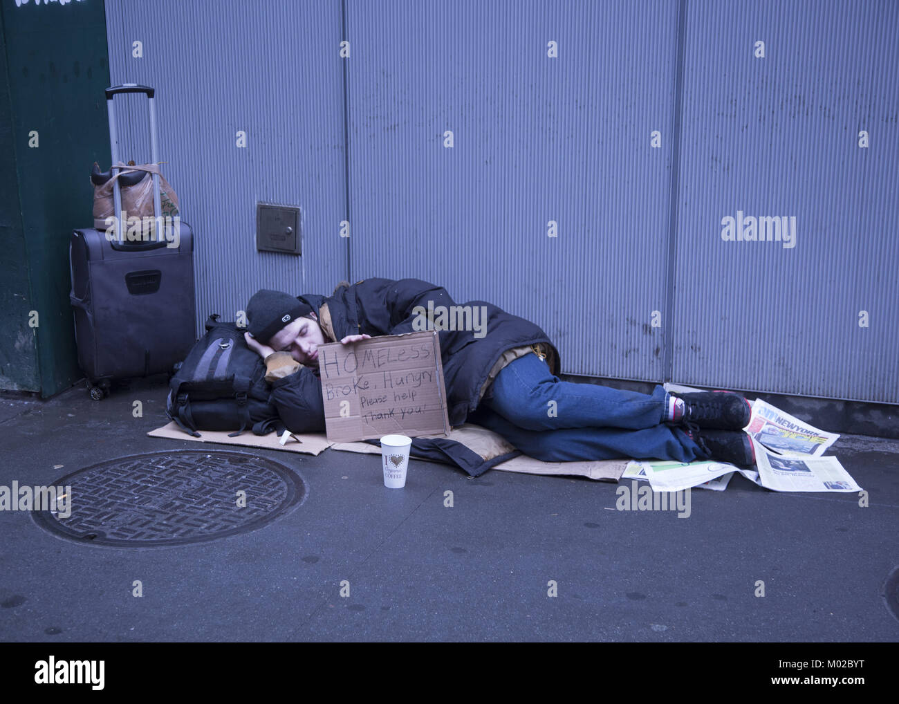 Jungen obdachlosen Mann schläft am Broadway entlang mit einem Schild um Hilfe zu bitten, in den Stadtteil Manhattan. NYC. Stockfoto