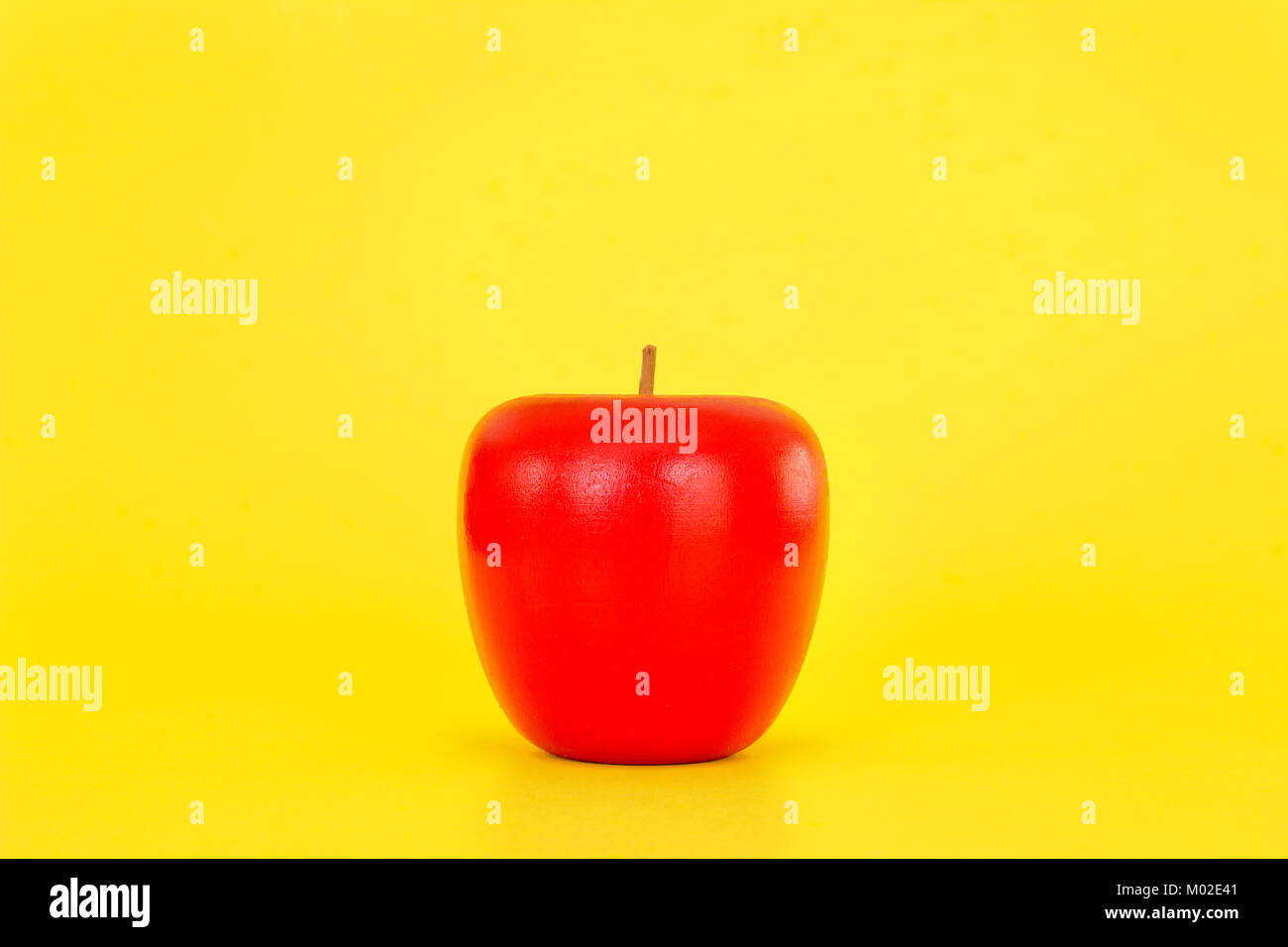 Künstliche Holz- Apple auf gelben Hintergrund. Stockfoto