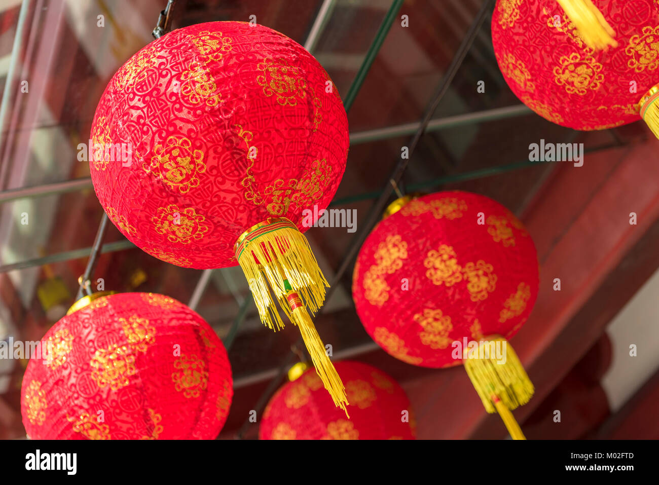 Rote Lampions mit gelben/goldenen Quasten Stockfoto