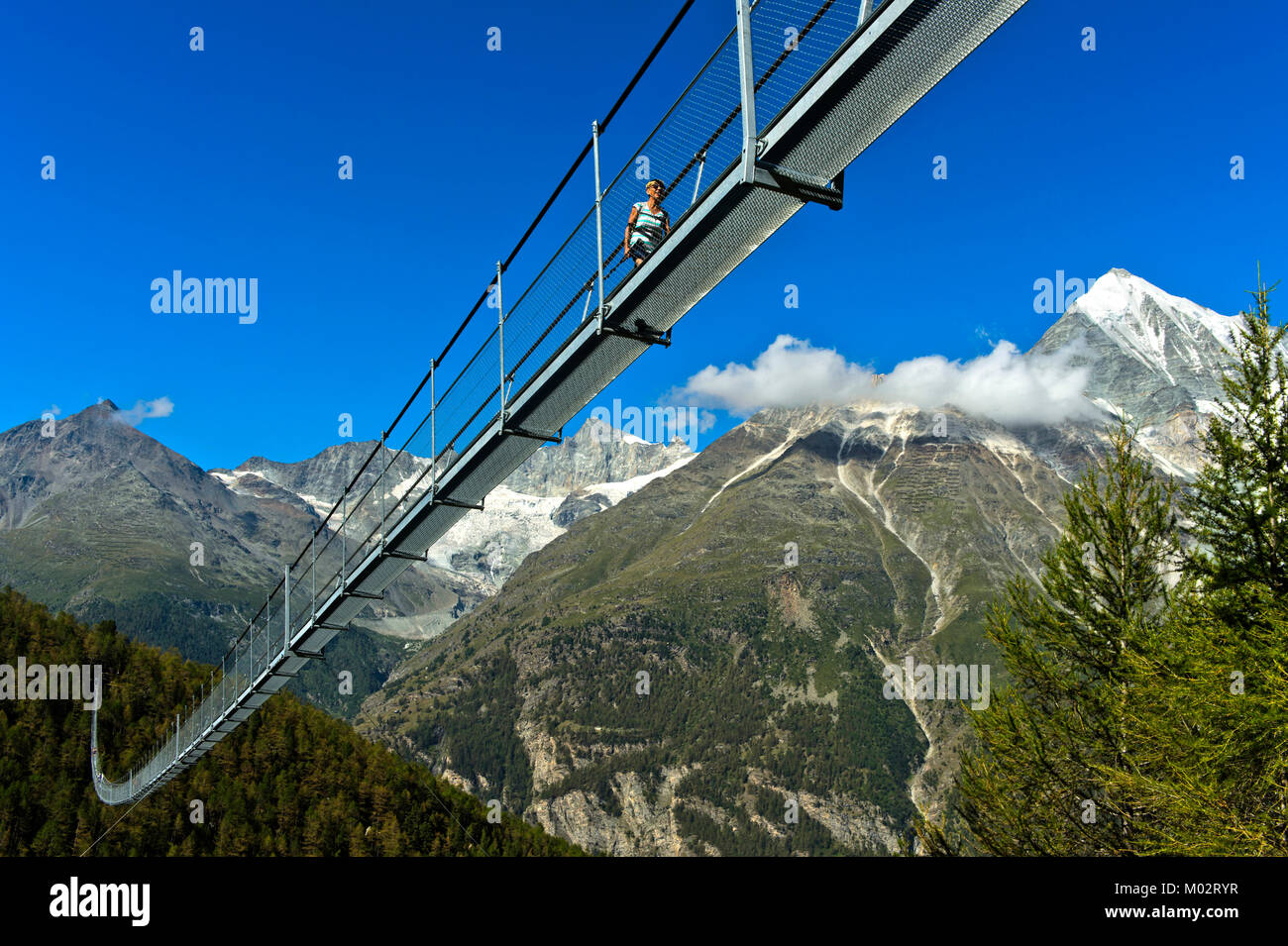 Wanderer auf dem Charles Kuonen Suspension Bridge, den weltweit gro§ten Erdolforderlandern zahlt längste Hängebrücke, mit dem Weisshorn Peak im Hintergrund, Randa, Kanton Va Stockfoto