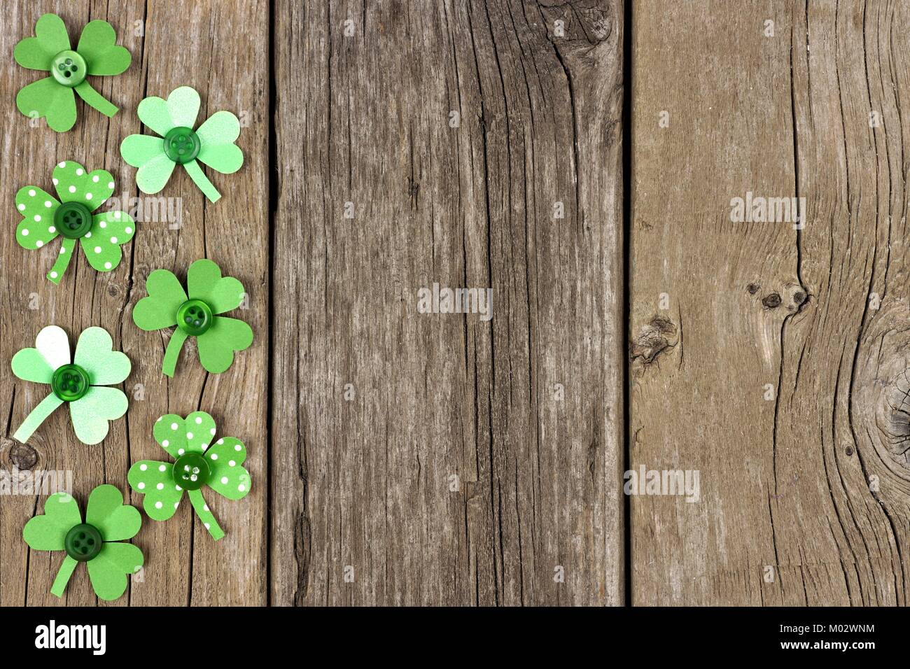 St Patricks Day Seite Grenze aus handgeschöpftem Papier shamrocks über eine rustikale Holz Hintergrund Stockfoto