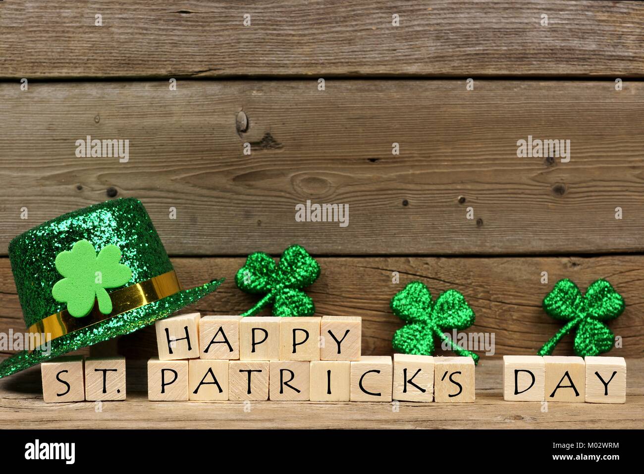 Happy St Patricks Day Holzblöcke mit glänzenden Shamrocks und Leprechaun hat auf einer hölzernen Hintergrund Stockfoto