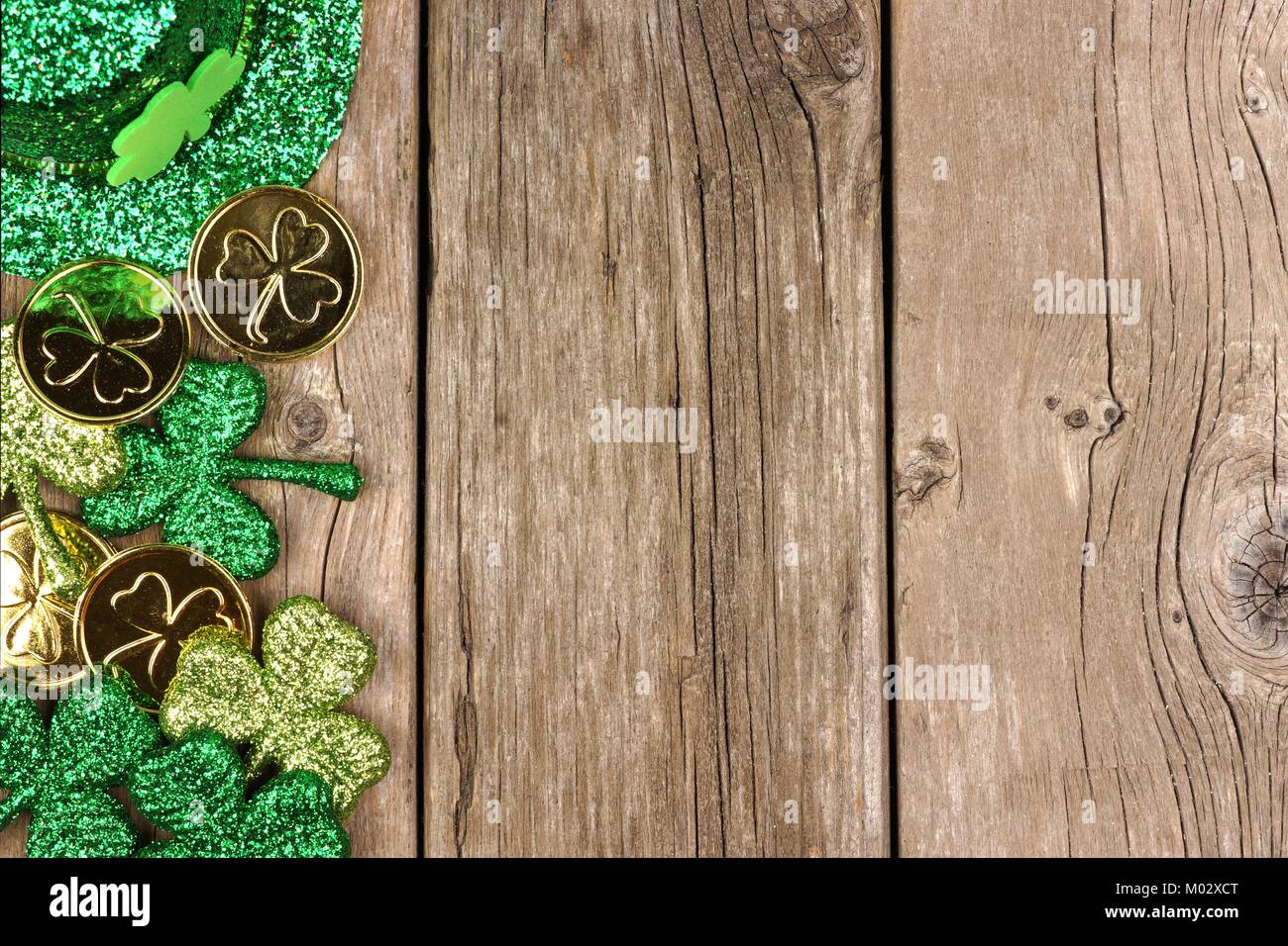 St Patricks Day Seite Grenze der Shamrocks, Goldmünzen und Leprechaun hat über rustikale Holz Stockfoto