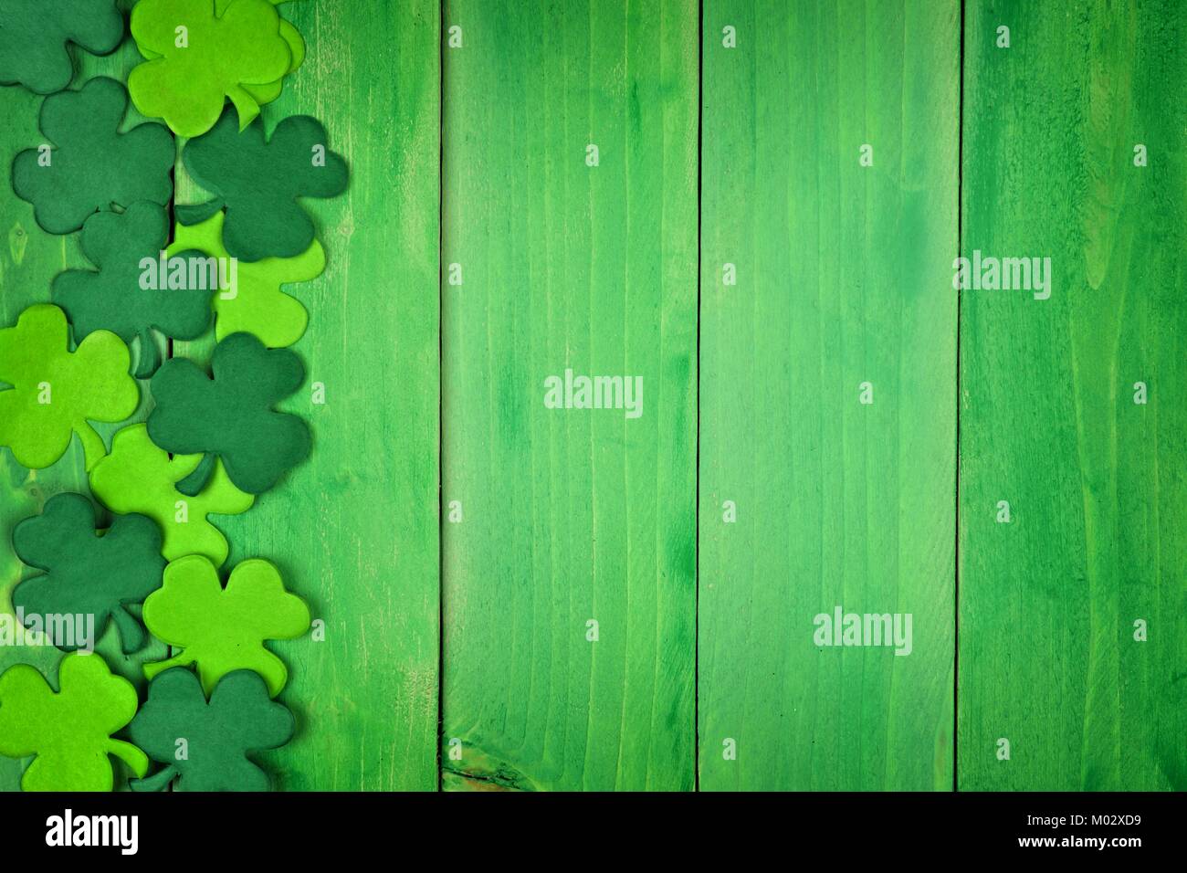St Patricks Day Seite Papier shamrocks über ein grünes Holz Hintergrund Stockfoto