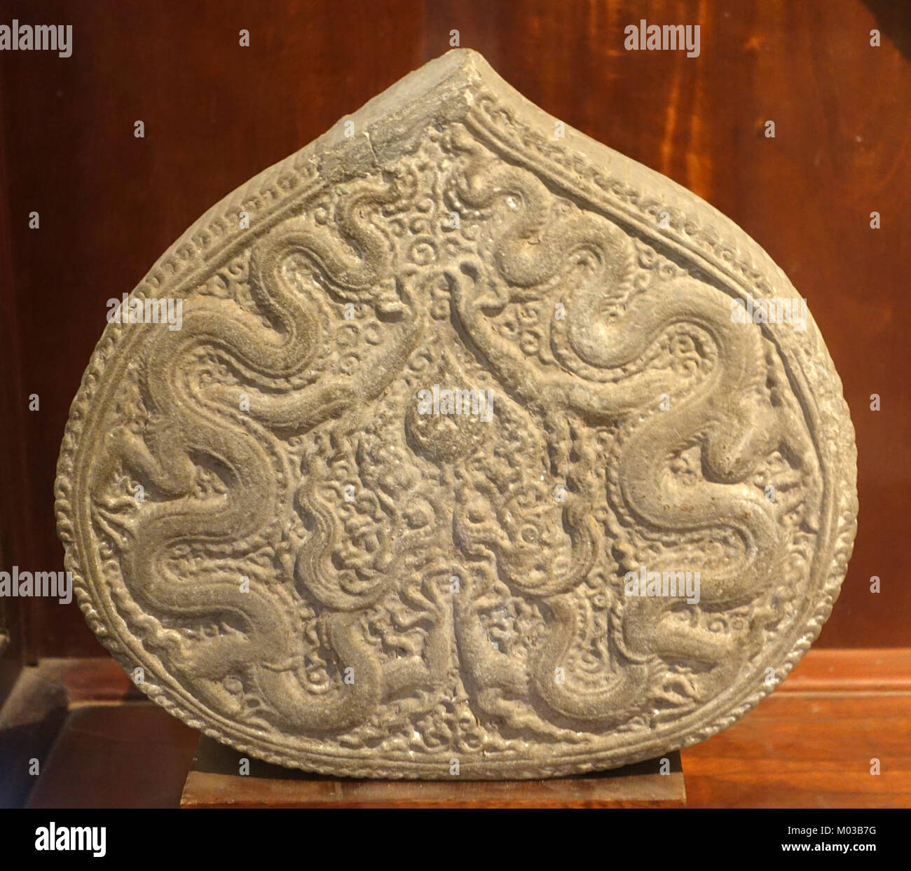 Foto eines Steinartefakts aus der Phat Tich Pagode in Bac Ninh, Vietnam, datiert auf 1057 n. Chr. Das Artefakt zeigt einen hellen, spitzen Kreis mit einem Drachen, der antike vietnamesische Kunst zeigt. Sie befindet sich im Vietnam National Museum of Fine Arts in Hanoi. Stockfoto