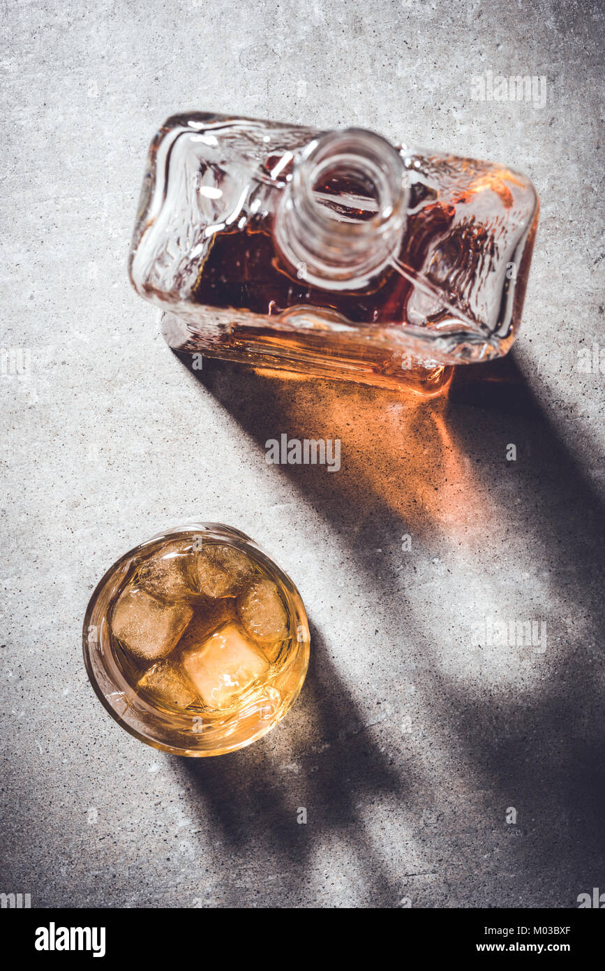 Flasche Whiskey und Whisky Glas auf grauem Stein Tabelle. Nahaufnahme Stockfoto
