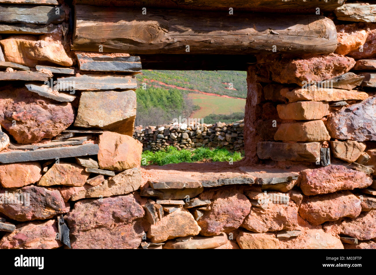 Blick durch eine windoiw auf einer Steinmauer. Madriguera, Provinz Segovia, Spanien. Stockfoto