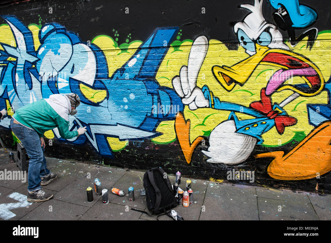 Brick Lane, East London ist eine kreative Zone für Künstler. Diese Bilder records Graffiti Künstler, beendet ein Stück Kunst. Stockfoto