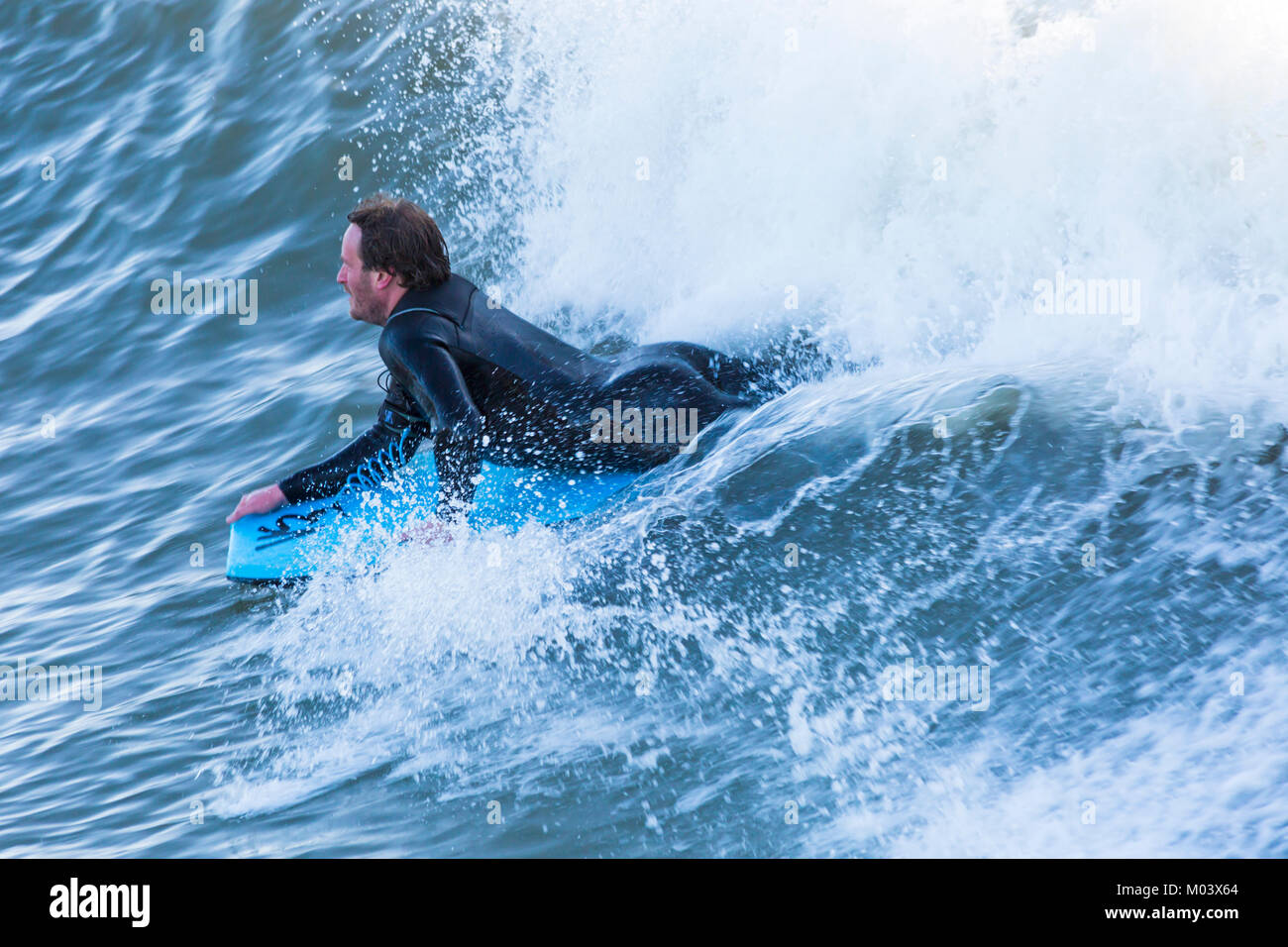 Bournemouth, Dorset, Großbritannien. 18 Jan, 2018. UK Wetter: Nach einer sehr windigen Nacht ein schöner sonniger Tag am Strand von Bournemouth. Surfer nutzen die großen Wellen und choppy Meeren. Surfer auf einer Welle. Credit: Carolyn Jenkins/Alamy leben Nachrichten Stockfoto