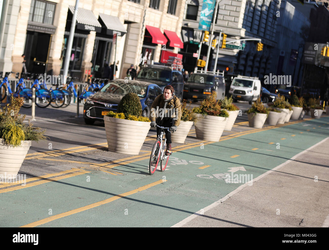 New York, USA. 18 Jan, 2018. Ein Mann fährt mit dem Fahrrad auf einem geschützten Radweg in Manhattan, New York City, USA, am 18.01.2018. New York (Department of Transportation, DOT) hat vor kurzem Pläne mehr geschützt Fahrradwege in Midtown Manhattan zu installieren Radfahrer zu schützen vorgestellt. Punkt hinzugefügt, um eine Aufzeichnung 25 Meilen von geschützten Radwege im Jahr 2017 mit seinen fast 1200 Meile Fahrrad Netzwerk. Credit: Wang Ying/Xinhua/Alamy leben Nachrichten Stockfoto