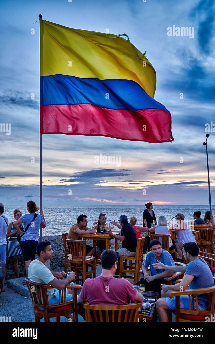 Winkende kolumbianische Flagge wieder Sonnenuntergang Himmel im Cafe del Mar, Cartagena de Indias Stockfoto