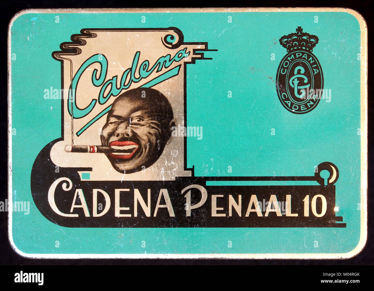 Dies ist ein Bild einer alten Zigarrendose mit der Aufschrift 'Cadena Penaal 10'. Die Dose ist ein Sammlerstück, das für sein Design und seine historische Bedeutung als Teil der Zigarrenkultur und der Tabakverpackung im frühen 20. Jahrhundert geschätzt wird. Stockfoto