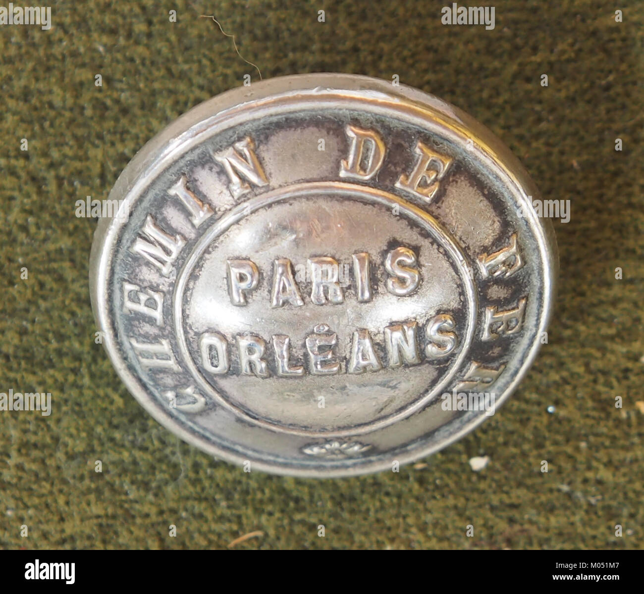 Der Knopf ist Teil einer Uniform aus dem *Ressau Etat Paris Orleans*, einem militärischen oder historischen Kleidungsstück. Das Design bietet einen Einblick in die Kleidungsstile oder Insignien, die mit dieser spezifischen Einheit oder Organisation verbunden sind. Stockfoto