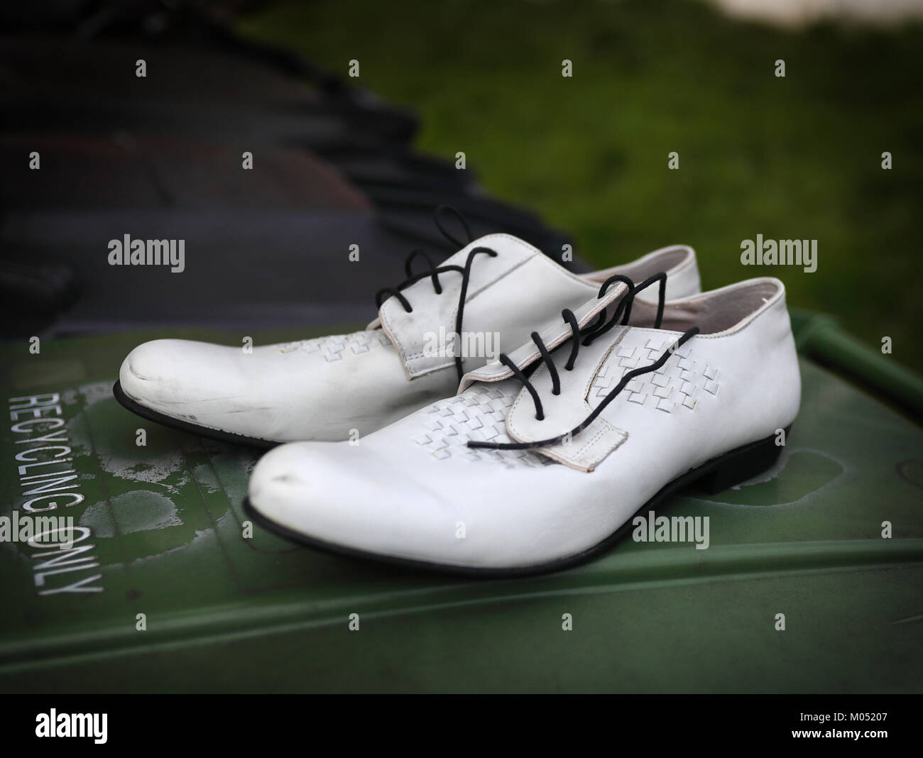 Paar smart Weiß retro Schuhe auf eine grüne Mülltonne links Stockfoto