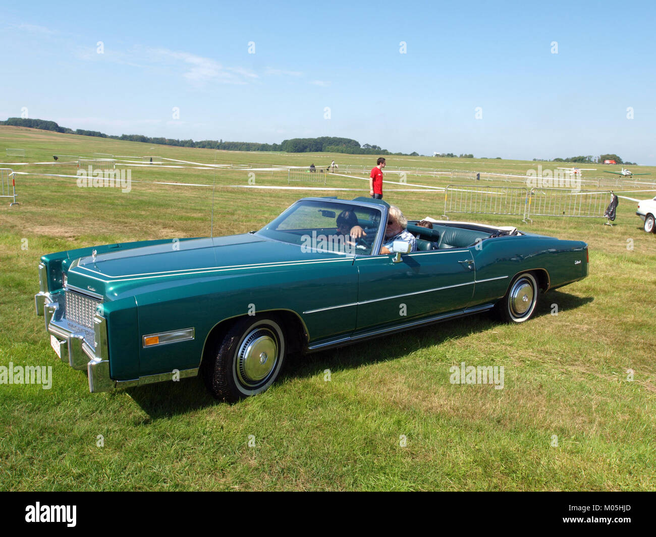 Dieses Bild wurde 2010 auf der International Oldtimer Fly and Drive in schaffen-Diest, Belgien, aufgenommen und zeigt ein klassisches Cadillac-Fahrzeug inmitten von Oldtimer-Flugzeugen. Stockfoto