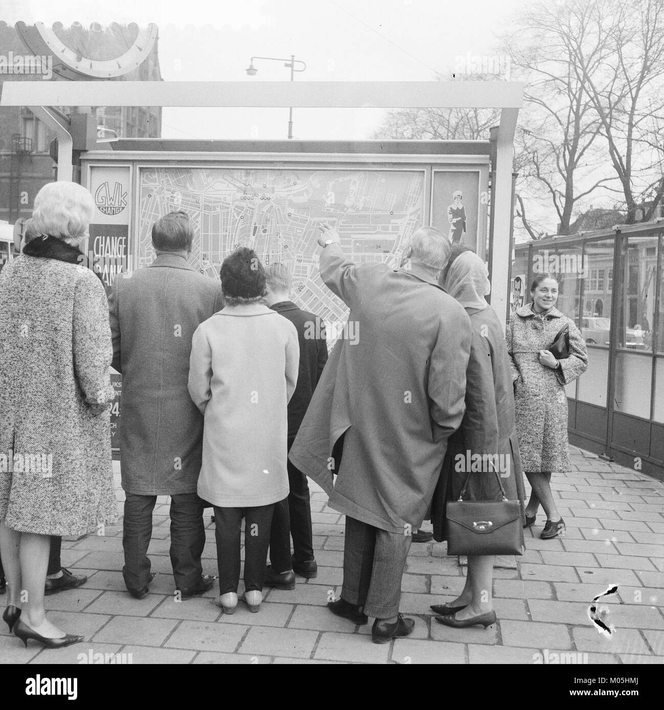 Das Bild zeigt Ausländer, die sich eine Karte in der Nähe des Centraal Station in Amsterdam ansehen. Das Foto, das Anfang des 20. Jahrhunderts aufgenommen wurde, zeigt die internationale Attraktivität der Stadt und ihre Rolle als Verkehrsknotenpunkt. Stockfoto