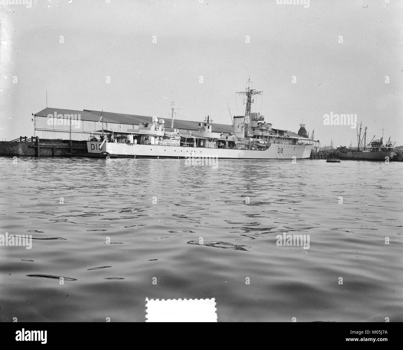 Ein britisches Kriegsschiff im Hafen von St. Kitts, aufgenommen in einem Bild, das die Geschichte der Marine und die militärische Präsenz in der Karibik während einer vergangenen Ära zeigt. Stockfoto