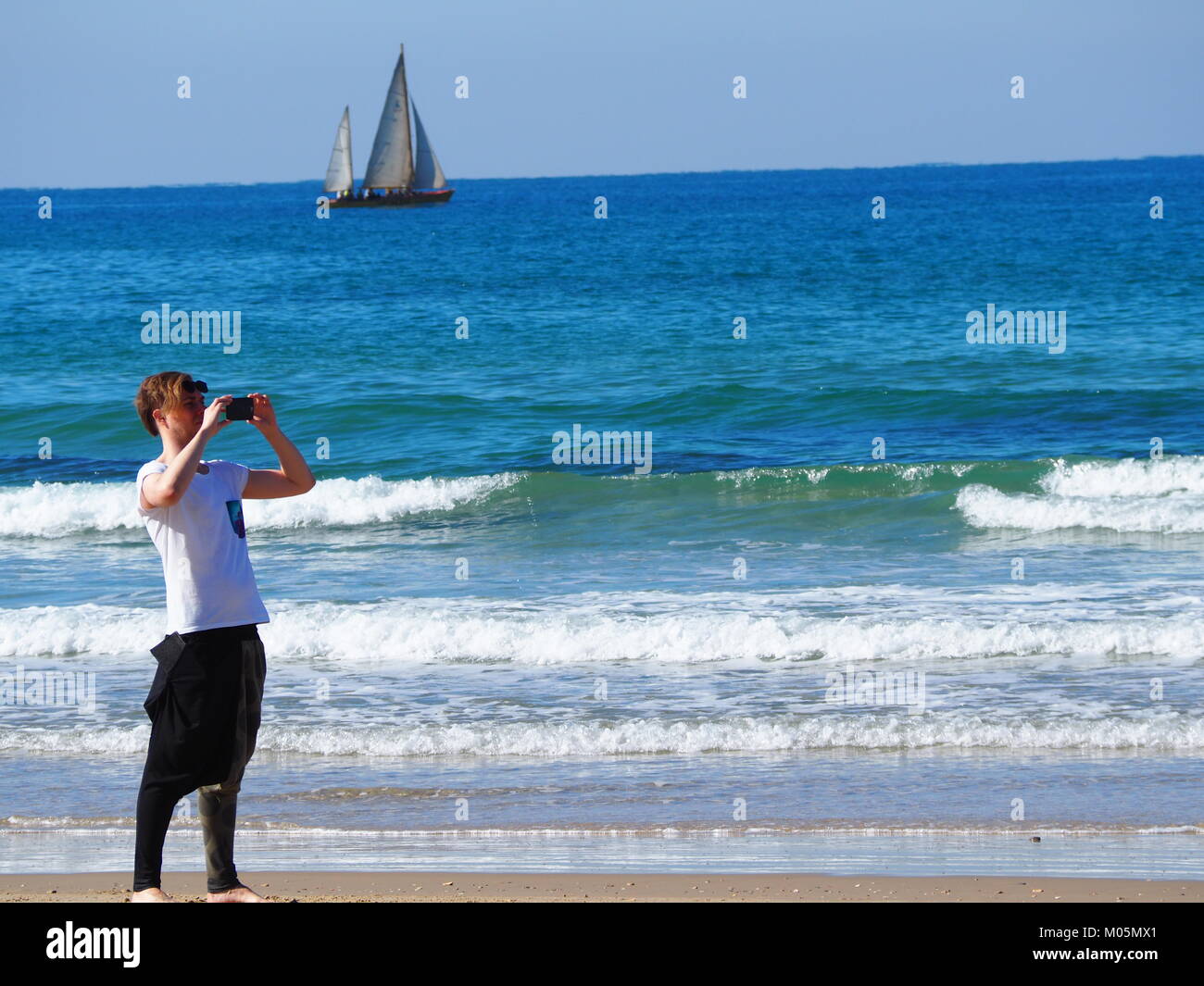 Erholung im Urlaub - ein Kerl ist, selfie Bild mit Segel Boot beim Stehen auf dem Strand Stockfoto