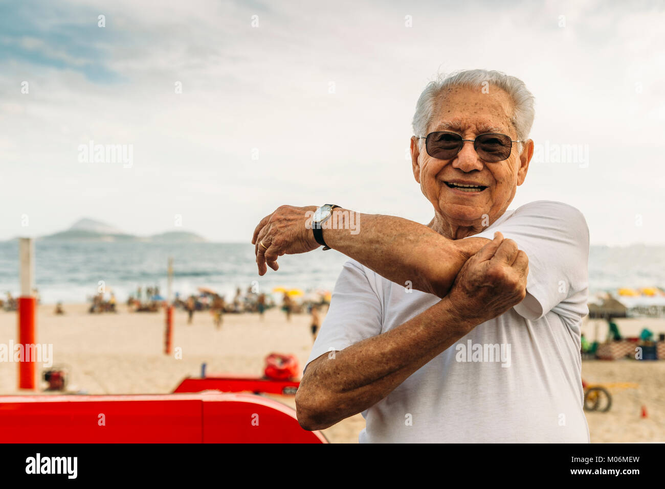 Model Released - Nahaufnahme von älteren Menschen (80-89) Dehnung triceps am Strand in Rio de Janeiro, Brasilien Stockfoto