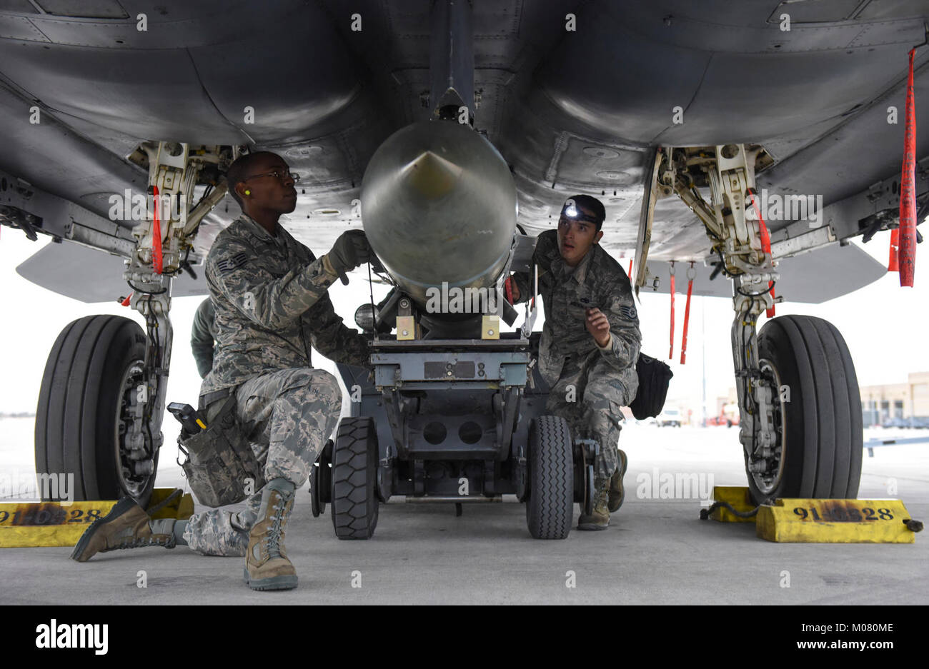 Staff Sgt. Brett Rosales-Carr, Staff Sgt. Mekai Stewart und Airman 1st Class Tristan McNay, 57 Aircraft Maintenance Squadron last Crew Mitglieder, laden Sie eine Markierung 84 Bombe auf einem F-15 Eagle fighter Jet während der Besatzung Wettbewerb des Jahres am Nellis Air Force Base, Nev, Jan. 8, 2018. Jeder Flieger spielte eine Rolle Erfolg Ihres Teams durch die Arbeit als eine zusammenhängende Einheit zu erhöhen. (U.S. Air Force Stockfoto