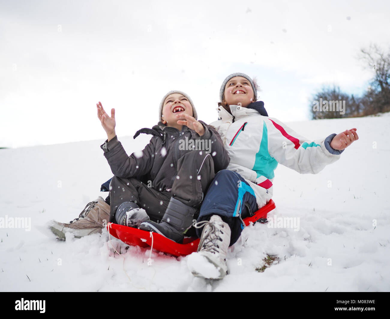 Kleines Mädchen und der kleine Junge im Schnee spielen Stockfoto