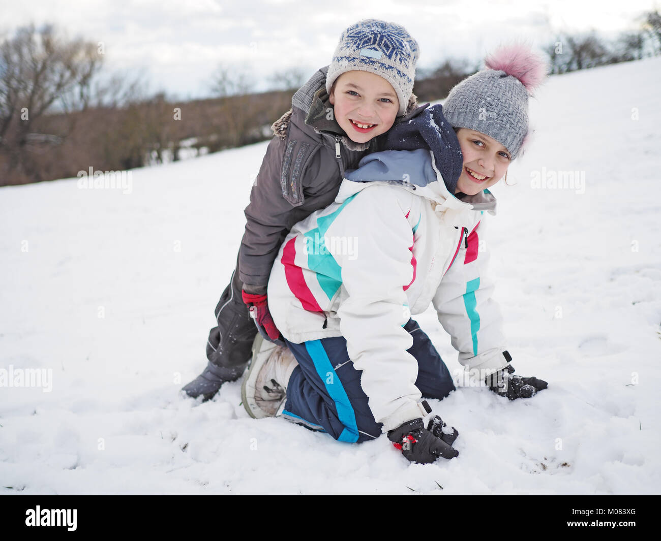 Kleines Mädchen und der kleine Junge im Schnee spielen Stockfoto