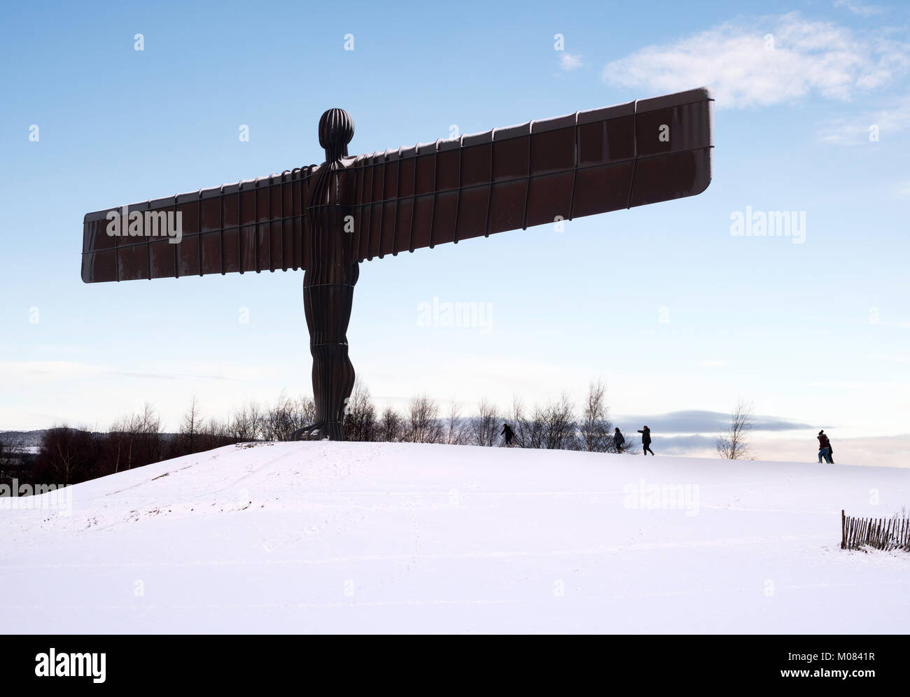 Eine Gruppe von Kindern Ansatz der Engel des Nordens Skulptur nach dem Winter Schnee, Gateshead, North East England, Großbritannien Stockfoto