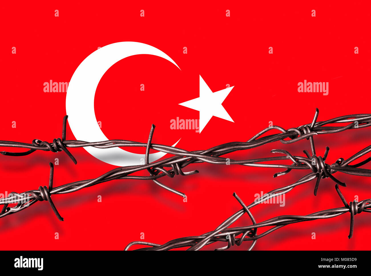 Stacheldraht mit Schatten vor einem türkischen Flagge Stockfoto