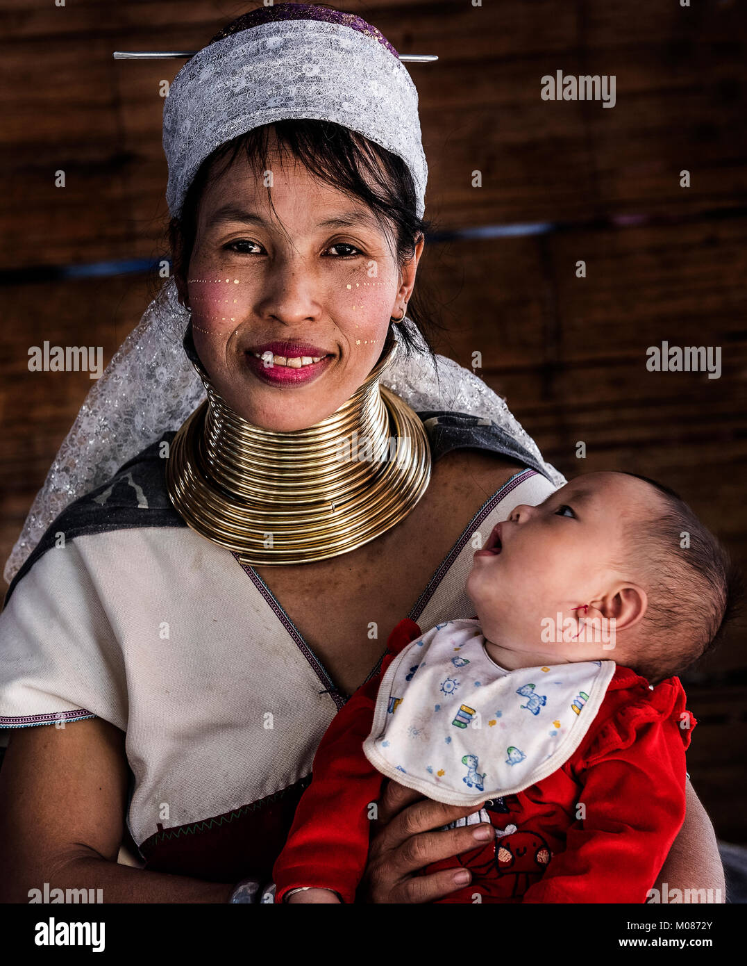 Portrait von langen Hals tribal Mutter und ihrem Baby sitzen vor dem Haus, Thailand Stockfoto