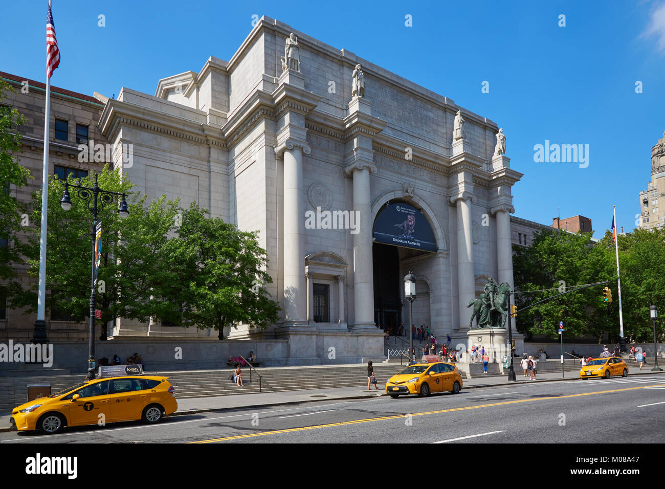 American Museum of Natural History Fassade mit Menschen und gelben Taxi an einem sonnigen Tag, blauer Himmel, New York Stockfoto