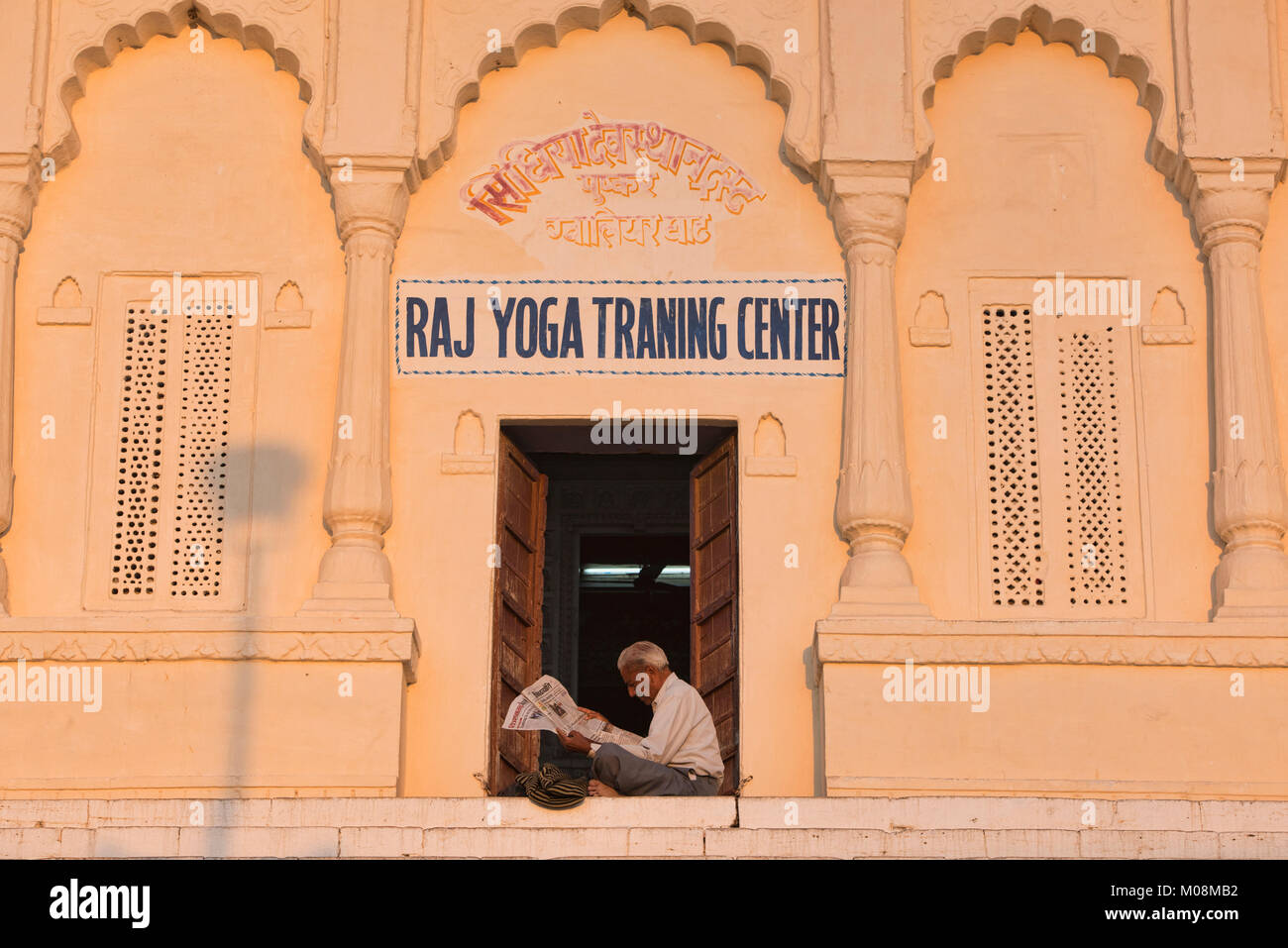 Yoga Lehrer Lesen in der Sonne, Pushkar, Rajasthan, Indien Stockfoto