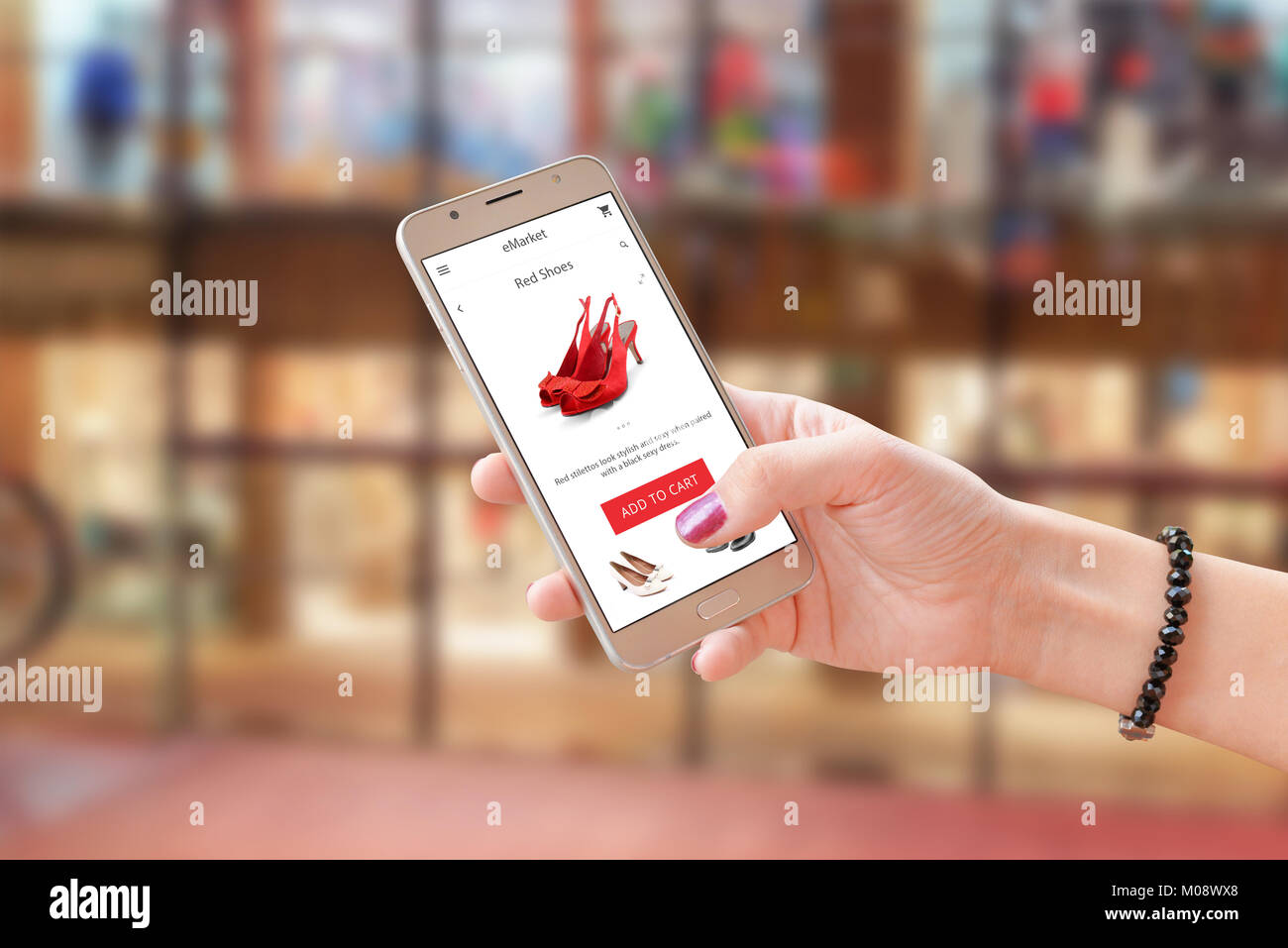 Online shoping mit Commerce App oder Website. Frau mit modernen smart phone. Einkaufszentrum im Hintergrund. Stockfoto