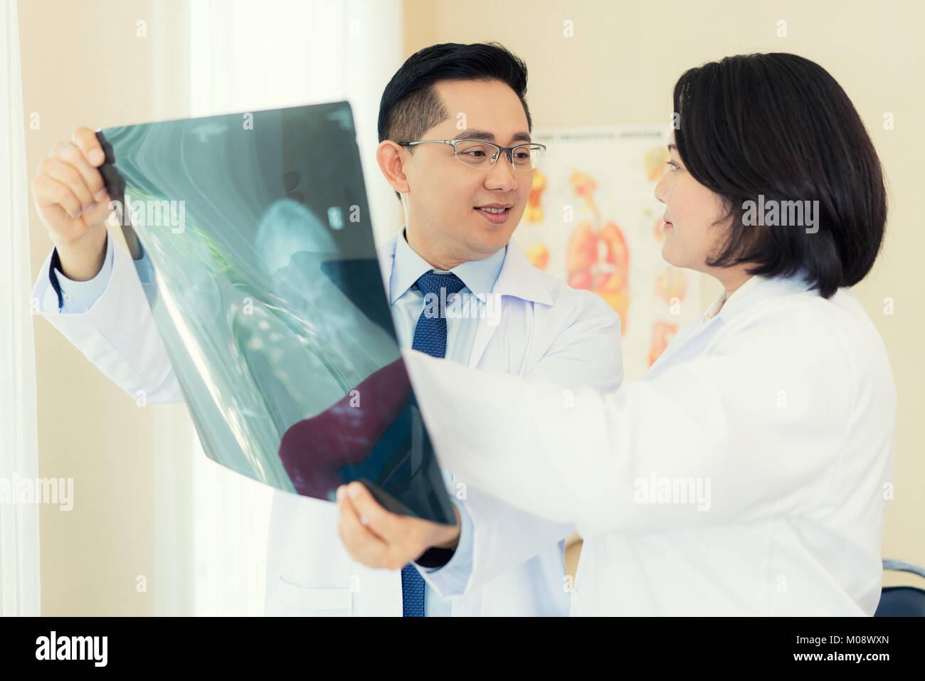 Zwei Arzt sprechen und Prüfung x-ray Film über Ergebnis und unscharfen Hintergrund Operationssaal mit X-ray Medizinische am Krankenhaus. Stockfoto