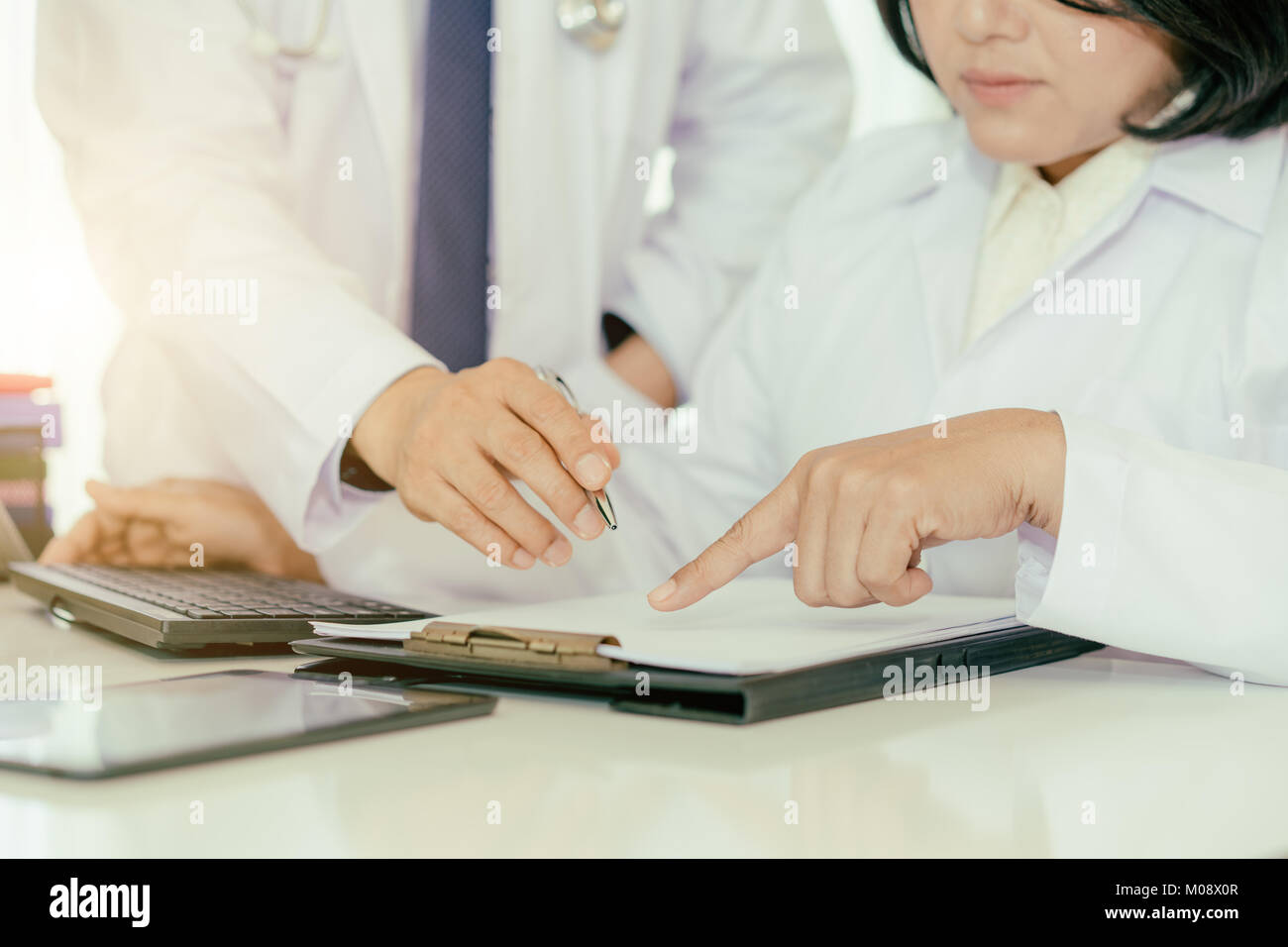 Zwei Doktoren der Analyse und Beratung über medizinische Aufzeichnung im modernen Krankenhaus. Asiatische Ärzte reden über Bericht. Stockfoto
