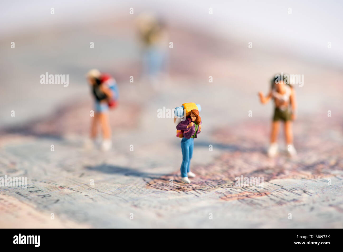 Gruppe von Miniatur junge Reisende mit Rucksäcken auf einer Karte mit flachen dof in einem Konzept der Reisen und Urlaub Stockfoto