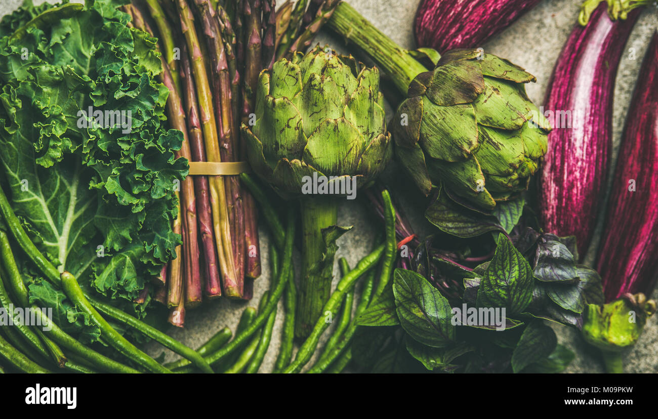 Flachbild-lay von Grün und Violett Gemüse über grauer Beton Hintergrund,  Ansicht von oben. Lokalen, saisonalen Produkten für gesundes Kochen.  Eggplans, grüne Bohnen, ka Stockfotografie - Alamy