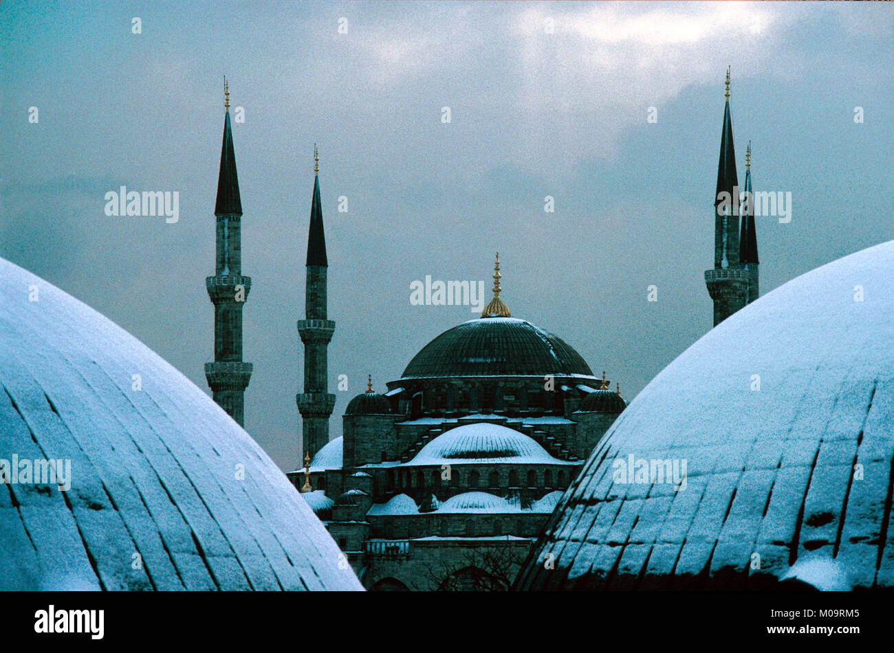 Kuppel und Minaretten der Blauen Moschee, aka Sultan Ahmed oder Sultan Ahmet Moschee unter Schnee, Istanbul in der Türkei. Im Vordergrund sind die Kuppeln des Grabes von Sultan Selim II (nach links) und Sultan Murat III (nach rechts). Stockfoto