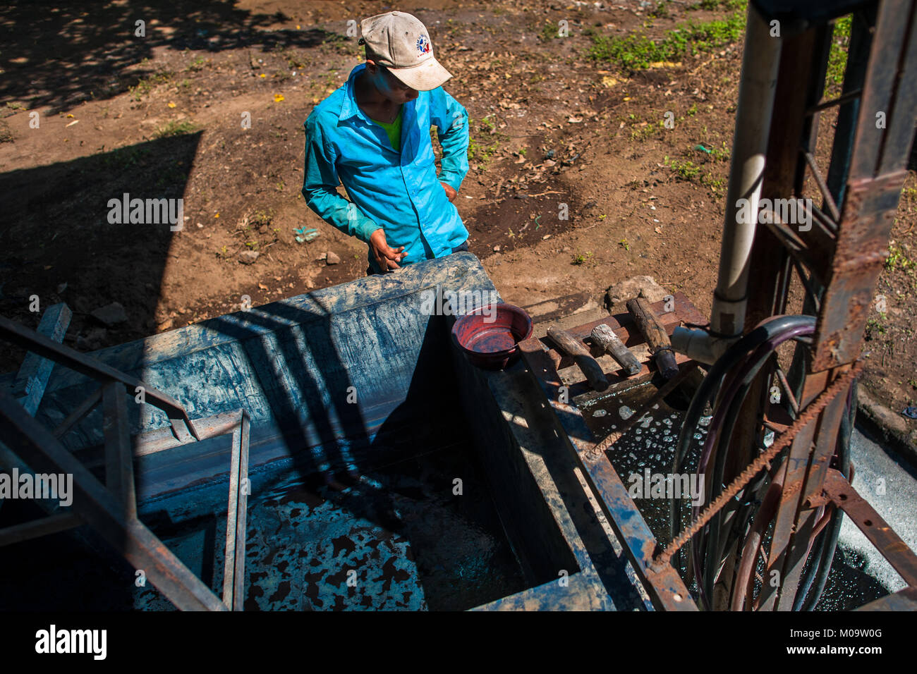 Ein Landarbeiter steuert die Indigo Verarbeitung in einem Tank bei der Herstellung in der Nähe von San Miguel, El Salvador. Stockfoto