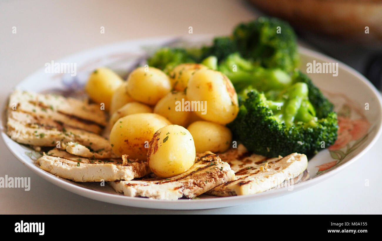 Veganes Essen, Tofu mit gerösteten Kartoffeln und Brokkoli. Stockfoto
