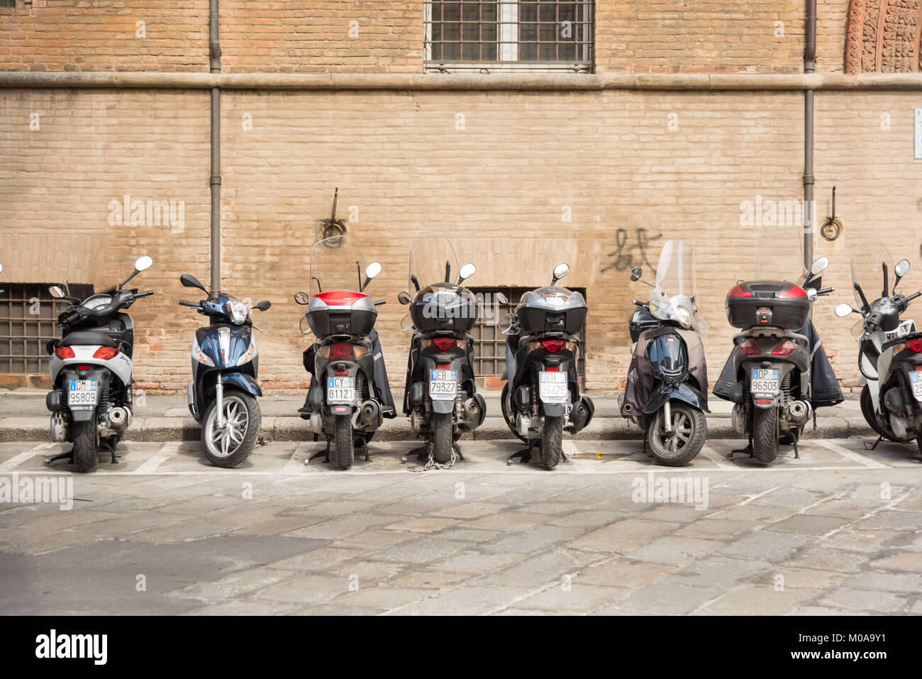 Eine Linie der Italienischen Mopeds, Roller und Motorräder in einer Linie auf einer Straße in Bologna Italien geparkt. Eine typische italienische Szene Stockfoto