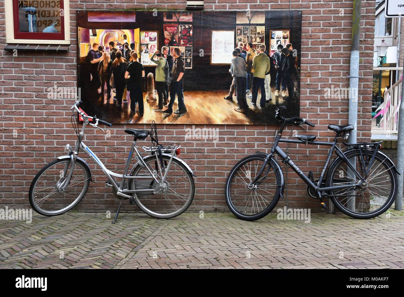 Fahrräder und Gestaltungsarbeit auf Mauer in Ommen Stockfoto