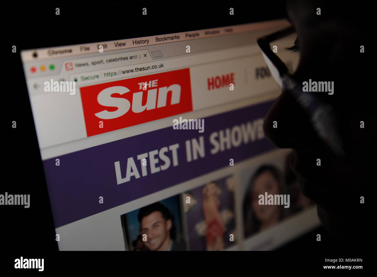 Eine Frau schaut auf der Sun Website Stockfoto