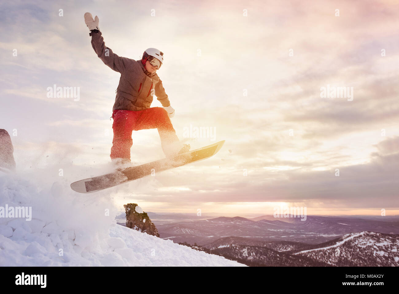 Snowboarder springt gegen Sonnenuntergang Himmel Stockfoto